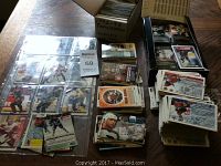 Wide view showing multiple stacks and piles of hockey cards including a box labeled 1992-93 Parkhurst complete 1-240, as well as loose cards and sleeved cards in a binder.