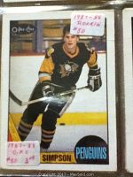 Close photo of a single OPC hockey card featuring a Pittsburgh Penguins player in black and yellow uniform skating on ice.