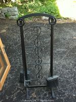 Photo of entire black steel fireplace tool set including stand and tools on outdoor surface