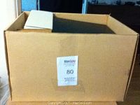 Box full and packed with sports cards and memorabilia inside a cardboard box, closed view