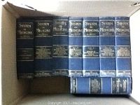Image showing 8 volumes of System of Medicine by Allbutt arranged in a cardboard box, dark hardcover with gold text on spine.