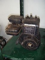 Single 2 HP Briggs and Stratton gas engine showing wear and dirt.