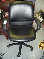 Front view of black leather office chair showing cushioned seat, backrest, and armrests.