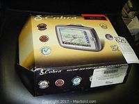Closed original box of Cobra NAV ONE 2100 GPS showing product graphics and branding.