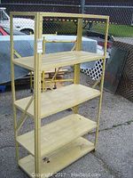 Full view of the 5-tier metal shelf showing the yellow painted frame and shelves with minor wear.