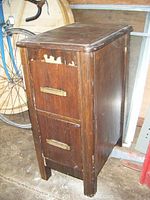 Full view of the nightstand showing two drawers with wooden handles and damage to veneer on one side.