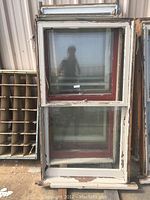 Front view of one reclaimed vintage double hung wood window showing white painted frame with red trim inside, glass intact on both sashes.