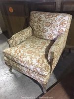 Overall view of the vintage French armchair showing floral upholstery and wooden cabriole legs, demonstrating condition and style