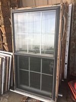 Set of five double hung wood windows with 6/6 panes visible, in vertical stack, showing condition and attached storm windows.