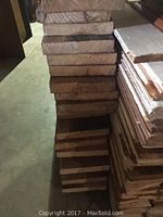 Stacked view of the reclaimed pine boards showing thickness, wood grain, and lengths around 9-10 feet