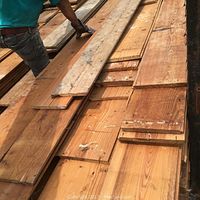 Stack of reclaimed pine shiplap boards showing width, surface patina, mixed lengths