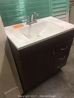 Front perspective of bath vanity assembly showing countertop, sink basin, cabinet drawers and door