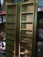 Pair of reclaimed wooden pantry doors standing vertically showing attached shelves and door hinges.