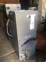 Front and side view of electric air handler cabinet showing Lennox logo and attached wiring.