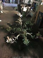 Side view of the decorative metal chandelier showing six arms with floral and leaf motifs and candle holders.