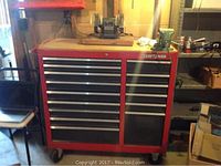 Full view of rolling Craftsman tool cabinet with wooden top, bench grinder and vise