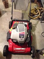 Front view of red Troy-Bilt lawn mower showing engine cover with 7.00 HP Briggs & Stratton Intek OHV label.