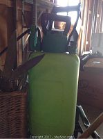 Green handheld pump sprayer with black handle and nozzle.