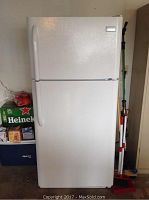 Front full view of white Frigidaire refrigerator with top freezer and single door handles.