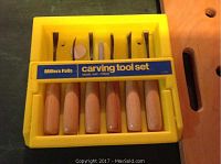 Photo of the Miller Falls carving tool set in yellow plastic case showing seven wood carving tools with natural wood handles and metal blades.