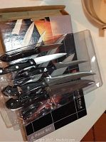 Kuchenstolz cutlery 5 out of 6 knives shown in original box, knives have black handles and stainless blades