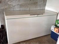 Full view of the white Sears Cold Spot chest freezer with a top-opening lid, showing rust spots and signs of age on the exterior.