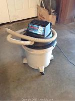 Craftsman Wet/Dry vacuum in grey/black with hose attached and mounted on base with wheels