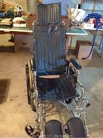 Frontal view of the Everest & Jennings Traveler wheelchair showing black leather padded back, seat, and headrest.
