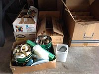 Four boxes containing assorted mason jars and lids. Lids are loose and also contained in smaller containers.