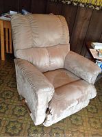 Front view of beige Lazyboy recliner chair showing plush cushioning and visible wear on fabric.