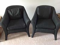 Front view of two black cushioned arm chairs side by side.
