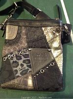 Black Coach small leather handbag with mixed patchwork designs, metal studs, and adjustable strap shown from front.