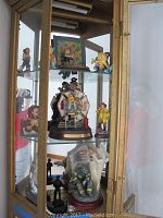 Glass-door cabinet overview containing all firefighting-themed figurines across three shelves