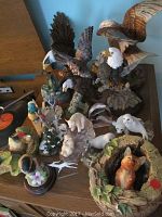 Overview photo showing the collection of animal figurines including eagles, fox, seals, and birds arranged on a table.