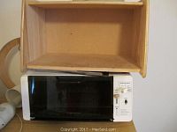 Empty wooden knife block storage space shown.