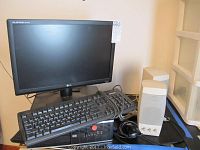 Full lot view showing HP tower computer, LG Flatron monitor, keyboard coiled and resting on tower, wired mouse on desk, and white stereo speakers.