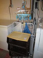 Photo of garment rack, mesh laundry hamper and yellow plastic basket with lid