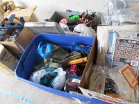 Multiple bins containing assorted action figures, packaging, vehicles and accessories