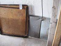 Photo of folded underside of a wooden folding table with metal legs showing wear and rust