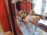Overview of glass display shelf showing horse, Southern Belle, child and dog figurine