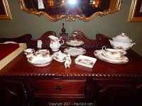 Full view of all pieces arranged on wooden sideboard under mirror