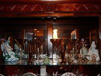 Display cabinet with wine glasses, ceramic figurines, and Swarovski elephant.