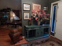 Full view of teal foyer table and decor items including rattan basket and wall art