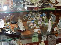 Front view of china cabinet shelves displaying porcelain decorative items