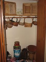 Closet shelf showing large rectangular nesting baskets and hanging woven baskets of various styles and sizes