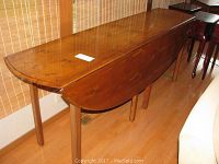 Full view of table closed with both leaves dropped showing narrow profile and straight legs