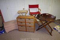 Overall group shot showing all items: beige ottoman, wood basket cabinet, red director chair, wooden tray table.