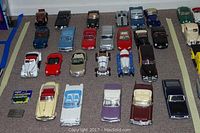 Overhead view of 26 die cast cars arranged in rows on carpet
