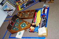 Wide view showing multiple games including Old Century Baseball game, wooden rebound ball game, boxed radio control Corvette car, and other game items scattered on floor.