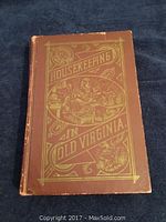 Front cover of the hardcover book with the title 'Housekeeping in Old Virginia' embossed in gold on a brown background, showing some wear.